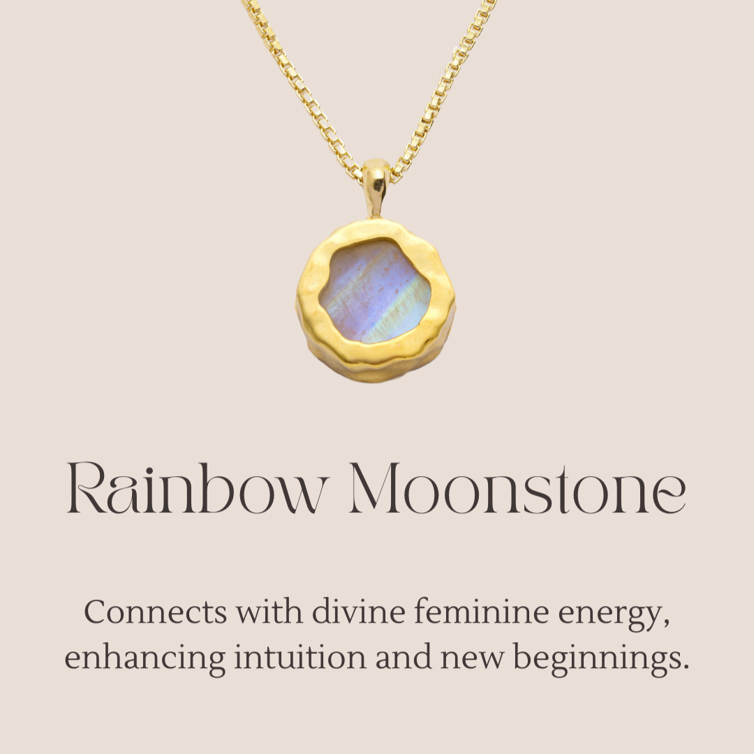 Gold necklace with a rainbow moonstone pendant on a beige background