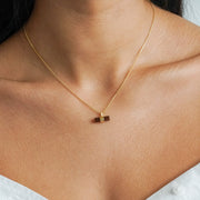 Dark brown smoky quartz pendant in a bar shape with a gold box chain on a models neck