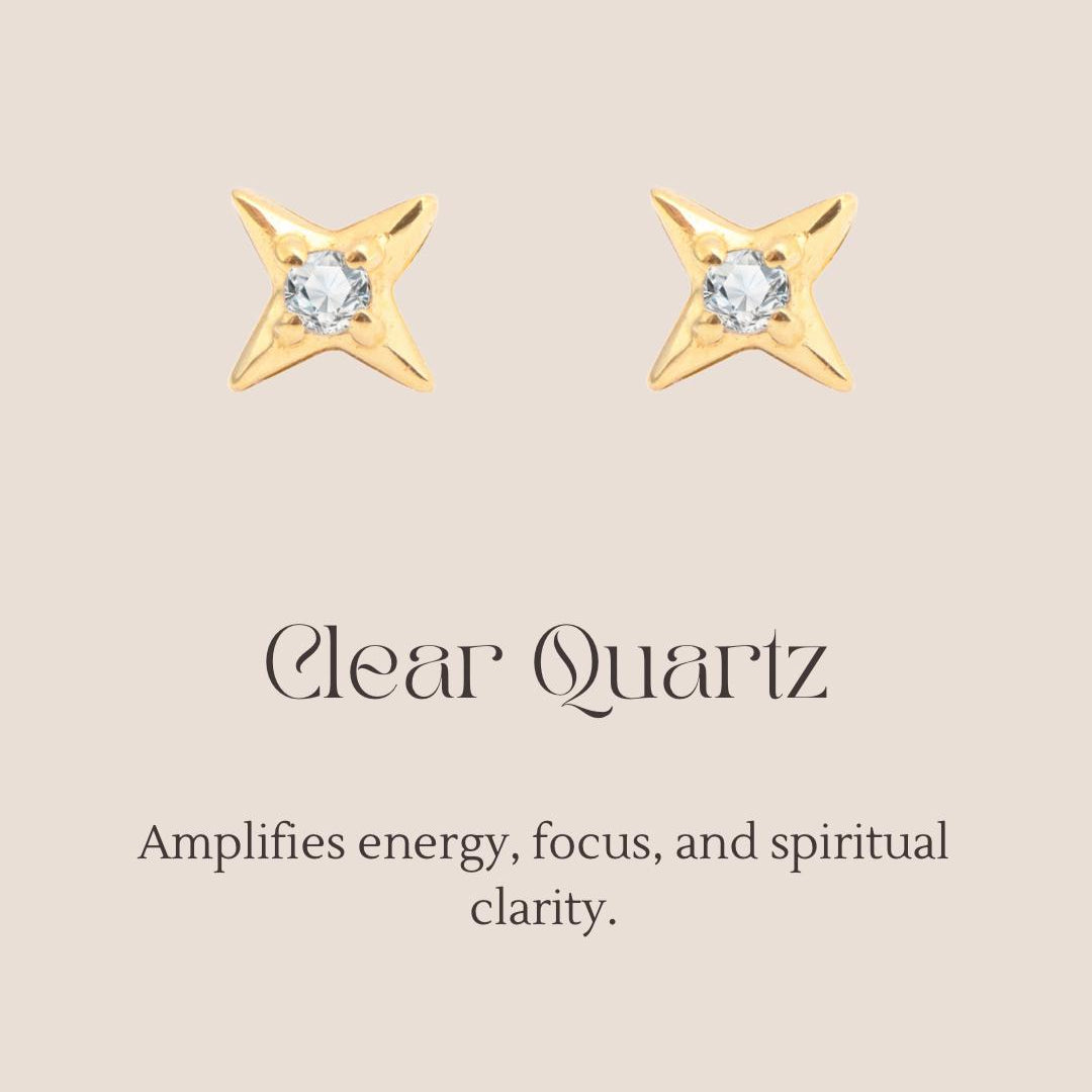 Gold star-shaped earrings with clear quartz stones on a beige background