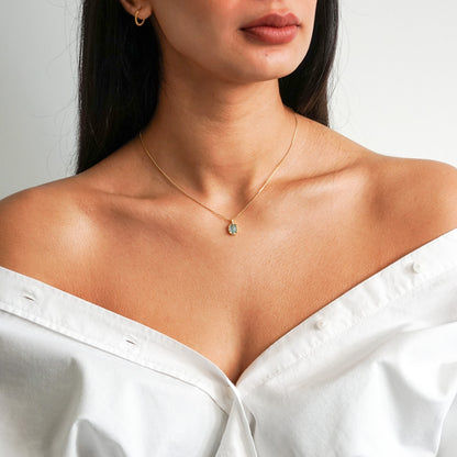 Aqua green oval aquamarine pendant with irregular faceting on an 18k gold vermeil box chain on model neck