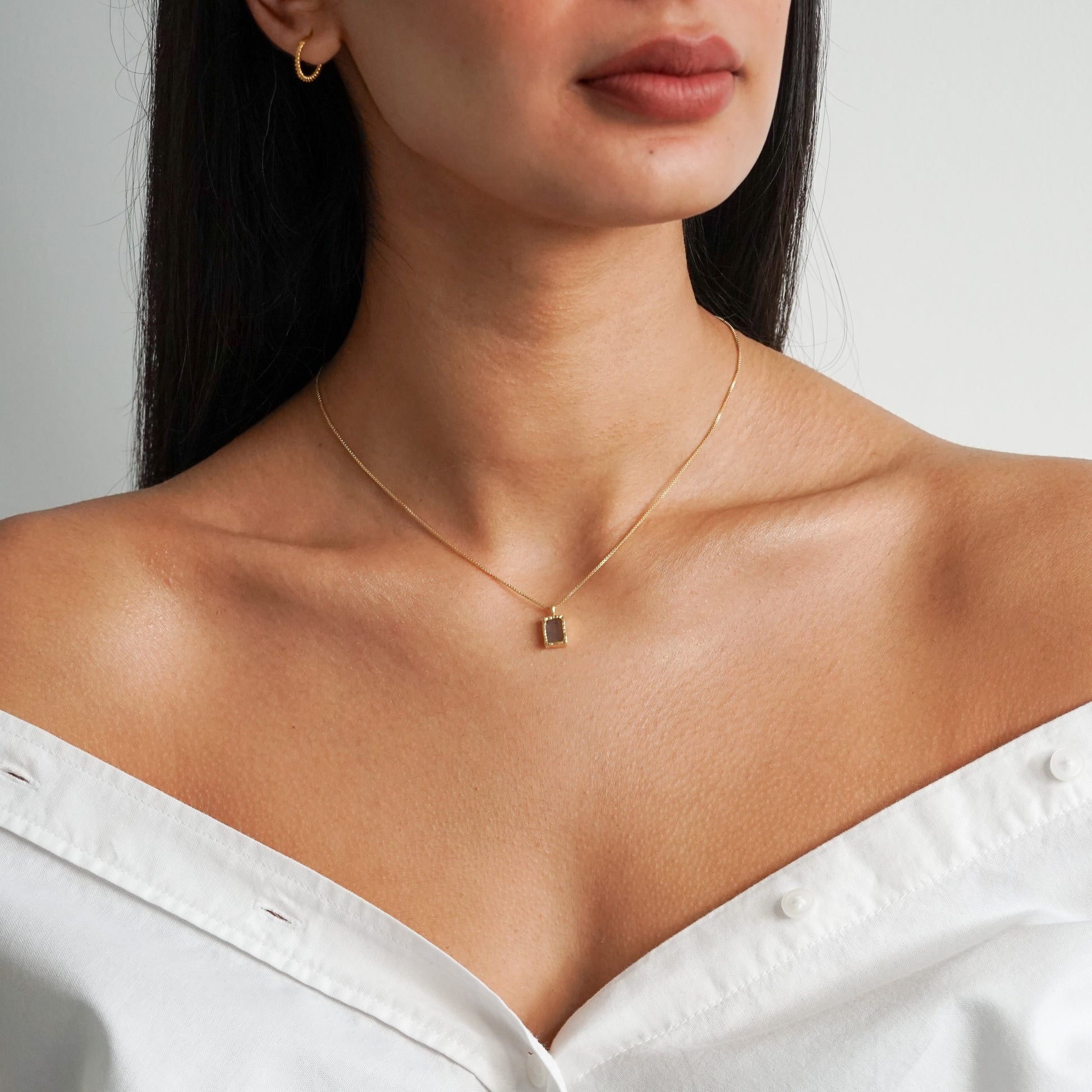 Rectangle flat labradorite pendant on an 18k gold box chain on a model neck