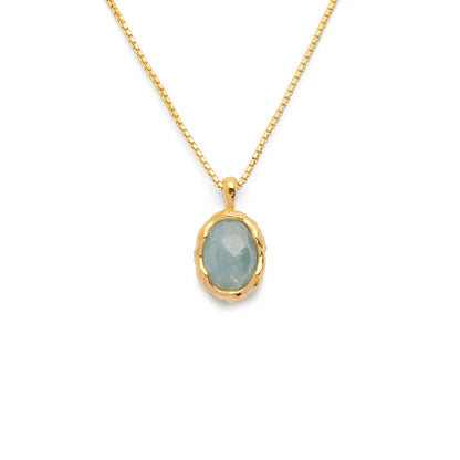 Aqua green oval aquamarine pendant with irregular faceting on an 18k gold vermeil box chain on a white background